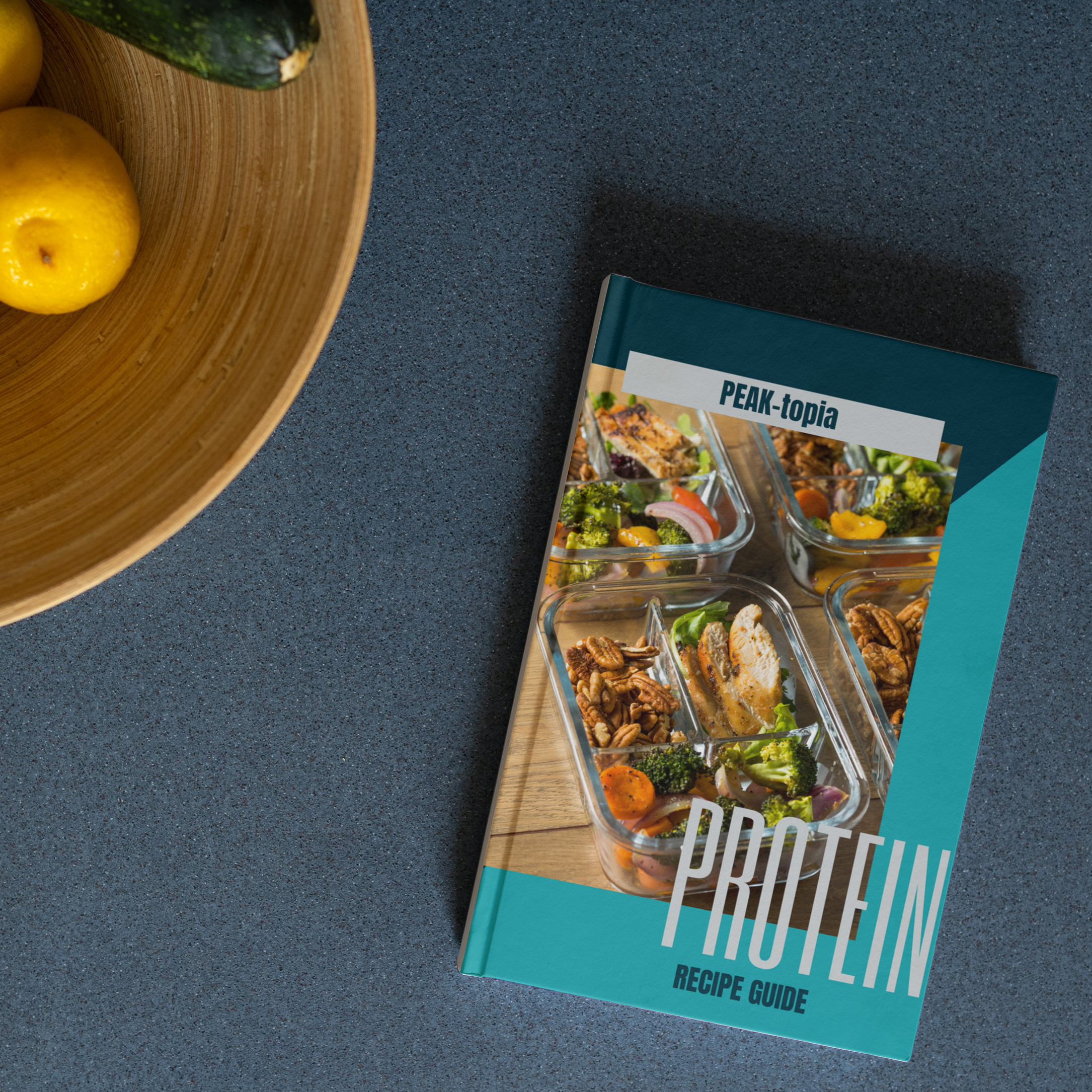 Portrait_hardcover_book_5.5x8.5_lying_on_the_desk_beside_the_fruit_bowl_PEAK_-_High_Protein_Recipe_Book_ Portrait_hardcover_book_5.5x8.5_lying_on_the_desk_beside_the_fruit_bowl_PEAK_-_High_Protein_Recipe_Book_